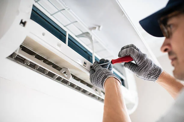 Technician performing precision maintenance on an indoor climate-control unit
