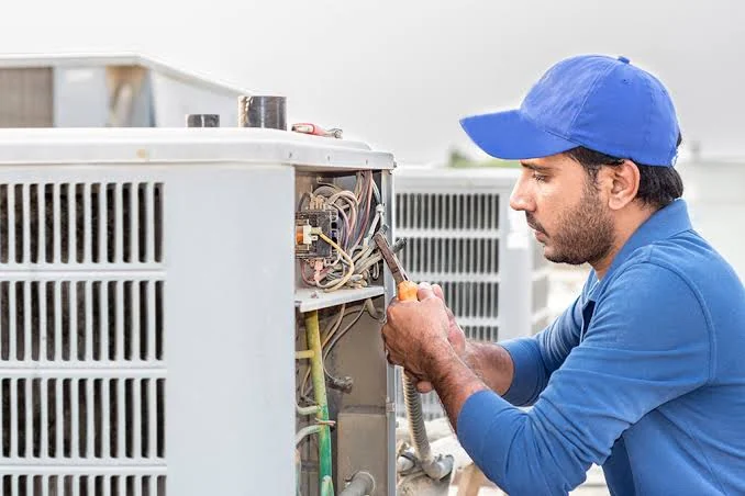 HVAC technician repairing an outdoor residential condenser
